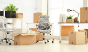 scatoloni e una sedia da ufficio imballata in un ufficio con ampie vetrate