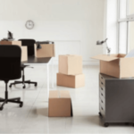 scatoloni accatastati in un ufficio con una sedia con rotelle ed una cassettiera grigia